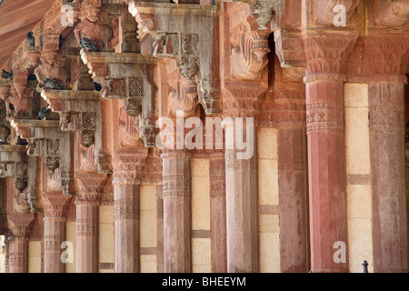 Fila di intricate sculture di pietra arenaria rossa colonne con capitelli Ganesha a Jaipur Forte Amber. Foto Stock