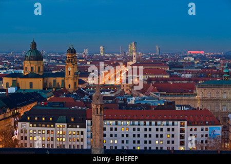 Theatinerkirche, aka Theatinerkirche San Kajetan (Teatini chiesa di San Gaetano) e la città di München (Monaco di Baviera) al tramonto. Foto Stock