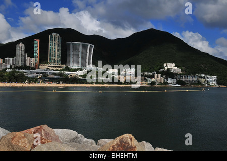Sunny View dello squalo net area spiaggia e appartamenti di lusso, contro una collina silhouette sullo sfondo, Repulse Bay, Hong Kong Foto Stock