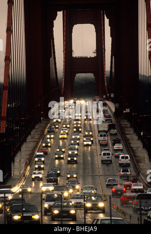 Ora di punta il traffico che passa sopra il Golden Gate bridge sul bagnato opaco sera, San Francisco, California, America, STATI UNITI D'AMERICA Foto Stock