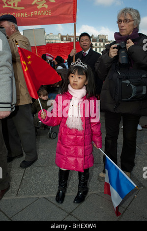 Parigi, Francia, famiglie asiatiche che celebrano la sfilata annuale del carnevale di strada del capodanno cinese, bambini, ragazza che regge bandiere francesi, immigrazione cinese, famiglia migrante, immigrati in Europa, comunità cinese di parigi, immigrazione, sventolando bandiere Foto Stock