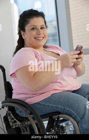 Donna disabile per la messaggistica di testo su un telefono cellulare Foto Stock