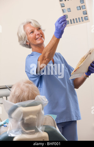 Dentista femmina esaminando un X-Ray relazione Foto Stock