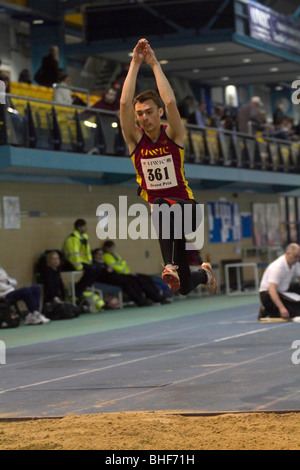 Atleta maschio compete nel salto triplo di un Gran Premio di soddisfare in Cardiff. Foto Stock