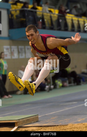 Atleta maschio compete nel salto triplo di un Gran Premio di soddisfare in Cardiff. Foto Stock