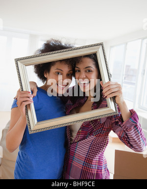 Amici guardando attraverso il fotogramma vuoto Foto Stock