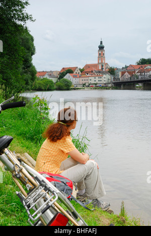 Donna seduta su Regen riverbank, Roding, Alto Palatinato, Baviera, Germania Foto Stock