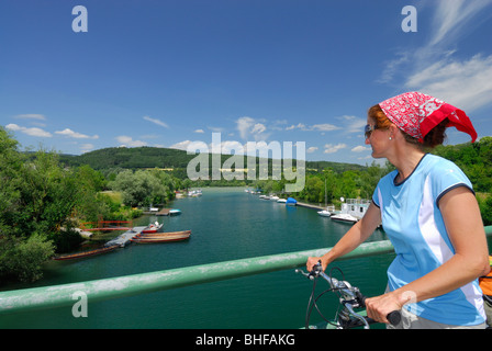 Ciclista femmina sul ponte sul fiume Erlauf, Danubio Percorso Ciclabile Passau Vienna, Poechlarn, Wachau, Austria Inferiore, Austria Foto Stock