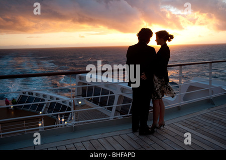Coppia giovane e guardare il tramonto, i passeggeri sul afterdeck, crociera, Queen Mary 2, transatlantica, Oceano Atlantico Foto Stock
