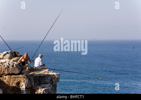 I pescatori seduti su una roccia, pesca vicino a Capo di Cabo de Sao Vicente, Oceano Atlantico, Sagres Algarve Foto Stock