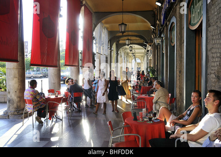 La gente seduta a portici in Via Roma, Cagliari, Sardegna, Italia, Europa Foto Stock