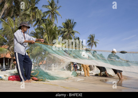 I pescatori con rete da pesca sulla spiaggia di Mui Ne, Binh Thuan Provincia, Vietnam Asia Foto Stock