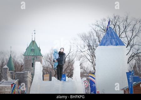 Un uomo e sua figlia preparare a cavalcare un Ice Slide al Québec Winter Carnival (Carnaval de Quebec) in Quebec City, Foto Stock