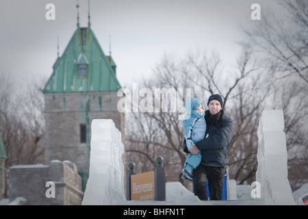 Un uomo e sua figlia preparare a cavalcare un Ice Slide al Québec Winter Carnival (Carnaval de Quebec) in Quebec City, Foto Stock