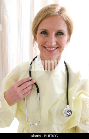 Medico professionista che indossa un giallo Copertura protettivo sopra i suoi vestiti. 523-1892.jpg Foto Stock