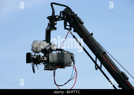 Fotocamera su gru in azione; cielo blu come sfondo Foto Stock