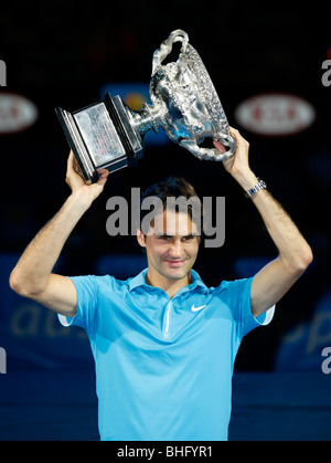 Roger Federer (SUI) tenendo i vincitori del trofeo in aria presso l'Australian Open 2010 a Melbourne, Australia Foto Stock