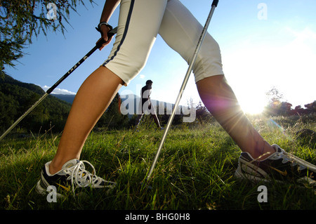 Nordic Walking, una donna di gambe su un prato sotto la luce diretta del sole, Val Venosta, Alto Adige, Italia, Europa Foto Stock