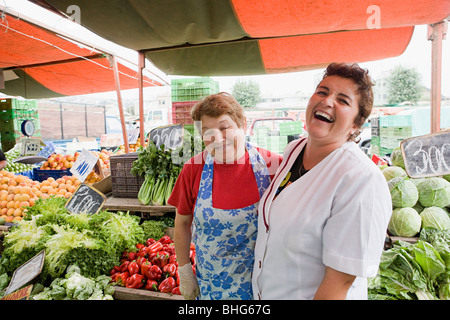 Due commercianti femmina su vegetali in stallo Foto Stock