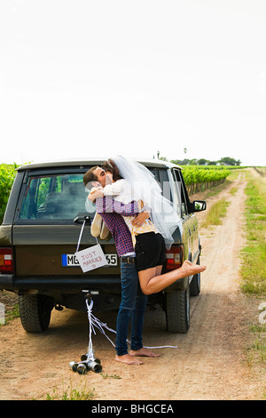 Sposa giovane baciare dal veicolo Foto Stock