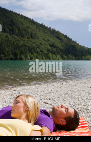 Una giovane coppia di rilassarsi in un lago Foto Stock