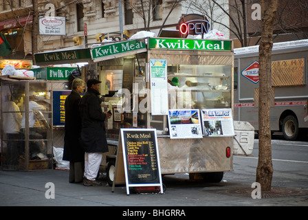 Diners line up per strada mediorientale il cibo al pasto Kwik carrello sulla sesta Avenue in New York Foto Stock