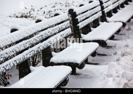 Coperta di neve panche in Battery Park, Manhattan New York City Foto Stock