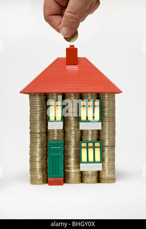 Una casa fatta di pile di monete da sterline e parti di un Bayko anni '60 - foto usa vecchie monete da £1 che sono state tolte dalla circolazione nell'ottobre 2017 Foto Stock