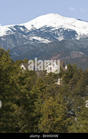 Sotto un cielo blu, nevato Sierra Blanca si affaccia su una isolata chalet nel Lincoln National Forest - Ruidoso, Nuovo Messico Foto Stock