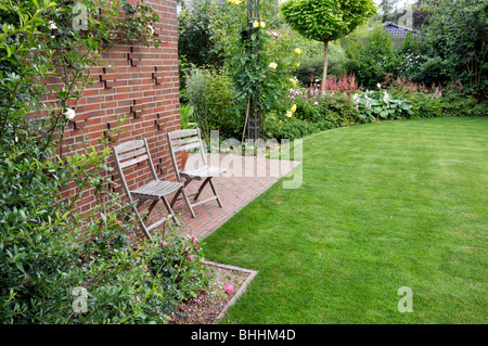 Prato con sedie da giardino Foto Stock
