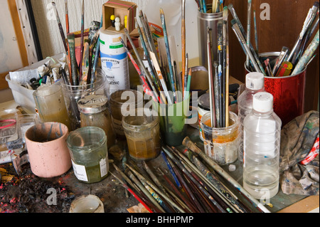 Spazzole vasi vasi bottiglie sul banco degli artisti studio Foto Stock