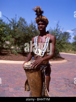 Uomo in abito nativo suonando la batteria, Victoria Falls Livingstone, sud della provincia, Repubblica di Zambia Foto Stock