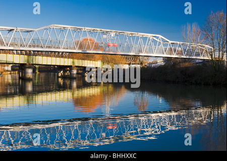 Il Footbridge Railworld oltre il fiume Nene, centro di Peterborough, CAMBRIDGESHIRE, con verde ponte ferroviario in background Foto Stock