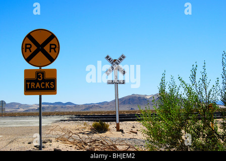 Attraversamento ferroviario segni contro il luminoso cielo blu Foto Stock