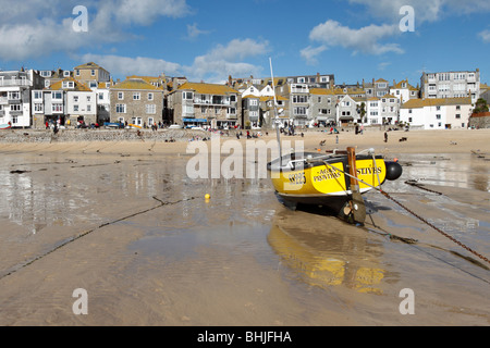 Una barca di colore giallo sulla St Ives Harbour Beach a bassa marea in una giornata di sole, Cornwall Regno Unito. Foto Stock