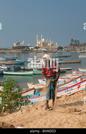 India Kerala, Kovalam, villaggio Vizhinjam fisherman tendente al suo reti da pesca Foto Stock