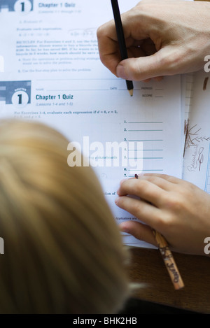 Studente a guardare come insegnante gradi quiz, close-up Foto Stock