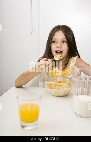 Ragazza mangiare cereali per la prima colazione Foto Stock