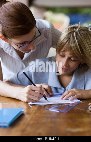 Aiutando l'insegnante di scuola elementare studente in classe Foto Stock