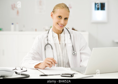 Medico donna a lavorare alla scrivania Foto Stock