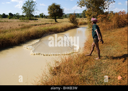 Un povero cambogiano lavoratore di riso con attività di pesca in una diga per proteina cibo da mangiare. Foto Stock