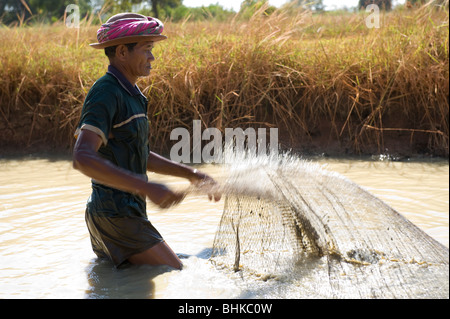 Un povero cambogiano lavoratore di riso con attività di pesca in una diga per proteina cibo da mangiare. Foto Stock