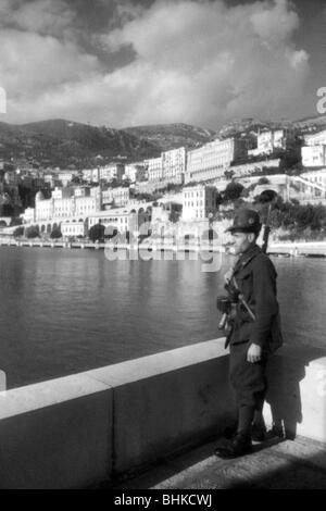 Geografia / viaggio, Monaco, politica, occupazione italiana e tedesca 1942 - 1944, soldato italiano al servizio di sentry sulla costa, probabilmente maggio 1943, Italia, Seconda guerra mondiale, seconda guerra mondiale, 20th secolo, militare, uniforme, uniformi, storico, storico, viste della città, città, case, principato, lunghezza completa, 1940s, persone, Foto Stock