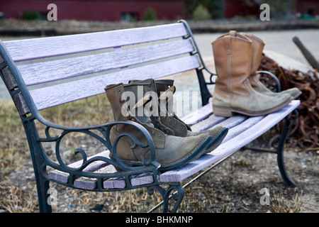 Vecchio stivali da lavoro a sedersi su una panchina in Buena Vista, Colorado. Foto Stock