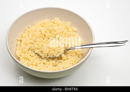 Ciotola piena di couscous cotto e un cucchiaio Foto Stock