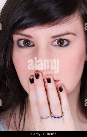 Bella giovane donna mano bocca di copertura Foto Stock