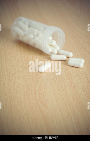 White pillole medicinali la fuoriuscita di una bottiglia Foto Stock