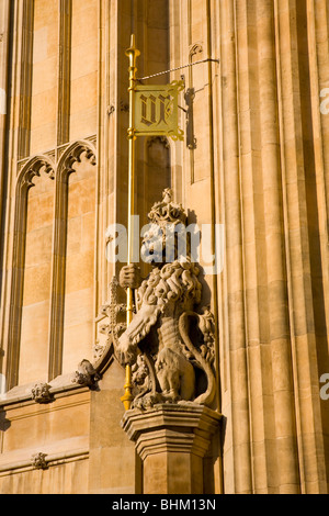 London, Greater London, England. Statua di leone accanto al sovrano di ingresso alla Casa del Parlamento. Foto Stock