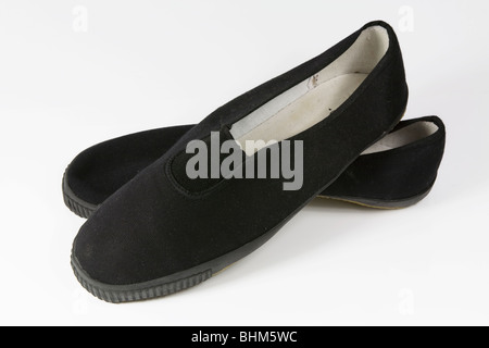 Coppia di slittamento nero-su plimsolls daps o. Foto Stock