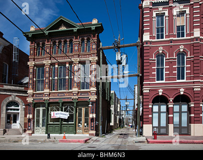 Le linee di alimentazione in esecuzione attraverso il viale tra due edifici storici Galveston Texas USA Foto Stock